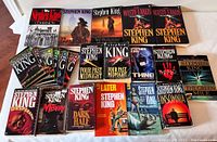 Overview of most Stephen King paperback books in the lot, showing varied titles including 'Thinner', 'Four Past Midnight', 'The Waste Lands', 'The Dark Half', 'Later', and others.