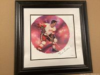Framed print showing Ted Lindsay in hockey gear with autograph on white mat.