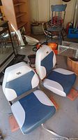 Pair of blue and white vinyl boat seats on wooden mounting boards, showing overall condition and style.