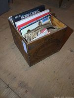 Side view of wooden butter box containing vinyl records visible inside