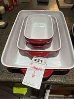Four nested Kitchen Aid ceramic casseroles in red with white interiors