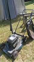 Full side and front view of Craftsman self-propelled gas lawn mower with attached grass bagger on lawn surface.