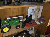 Full center shelf view showing tractor, steam engine, VW toy, shadow box, print, and book