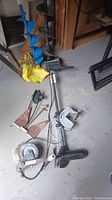 Overview of trolling motor, anchor, winch and clapper device on concrete floor.