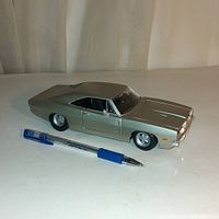 Grey die cast Dodge Charger RT toy car approximately 8 inches in length placed next to a pen for scale