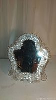 Front view of Murano vanity mirror showing the glass bead border and glass flower accents around the mirror surface.