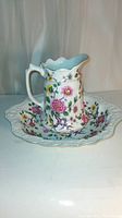 Front view of porcelain jug and matching bowl showing floral design and shape