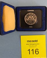 Photo showing the Canadian silver dollar coin in the open presentation case with the coin side featuring a canoe and the year 1972.