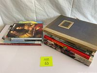 Two stacks of art books and a loose-leaf binder on white background