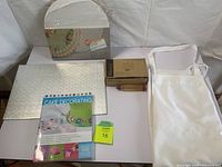 All items together showing the book, cake circles, sheet board, decorator bottle, icing pen, and apron.