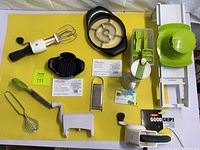 Overview of kitchen tools set including Pampered Chef mandolin, French fry cutter, OXO mixer, graters, and other kitchen utensils on yellow background.