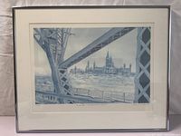 Framed print showing architectural composition of Ottawa Parliament buildings viewed from the Interprovincial Bridge, detailed steel structure frame in foreground.