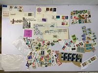 Top view showing four British First Day Covers with Christmas stamps spread out above a large group of assorted loose cancelled stamps