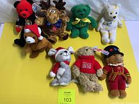 Full view of all 8 assorted stuffed animals laid on a white surface