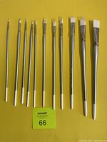 Full view of 11 new Silverwhite 1502 Bright paint brushes arranged by size on a yellow background.