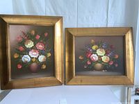 Pair of floral oil paintings in gilt wood frames, one portrait and one landscape orientation.