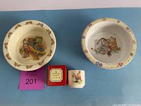 Full set including Bunnykins egg cup with original box, Bunnykins cereal bowl, and Winnie the Pooh cereal bowl all displayed together on blue background.