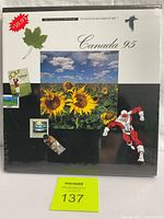 Front cover of 1995 Canadian Stamp Collection sealed package featuring sunflowers, maple leaf, and a superhero figure.