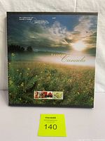 Front view of embossed hardcover book showing misty field cover with stamp images and title text.