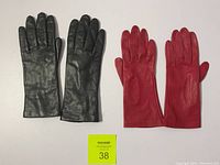 Top view of black and red leather gloves showing front side and fingers.