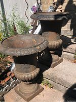 Both urns side by side on stone steps showing overall design and condition