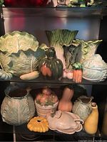 Overview of entire Fitz And Floyd vegetable-themed ceramic collection arranged on shelves showing detailed vegetable shapes and colors