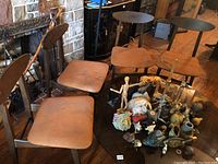 Four Mid Century Modern dining chairs around a glass table showing condition and design.