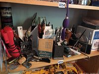 Shelf with various vintage office supplies including pens, calendar, pipes, and stamps.