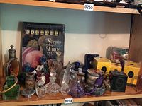 Shelf display with decorative perfume bottles, metal‐top jars and boxed fragrances visible
