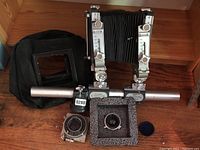 Overall view of Plaubel camera body on monorail with bellows, two lens shutter boards, mounting boards, and blue lens cap.