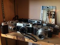 Six rangefinder cameras on shelf showing overall lot
