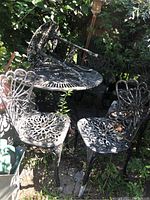 View of stacked patio table and chairs outdoors showing overall set and condition