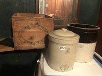 Photo showing the wooden butter box stamped with 'Canadian Butter Ontario' next to two ceramic crocks, one with a lid.