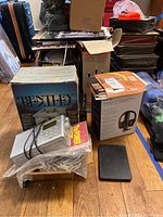 Bentley portable black and white TV box, Coby radio, floppy disk, and manuals on floor