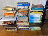 Left stack of classic fiction books including The Journals of Sylvia Plath, Alice in Wonderland, and works by Anne Sexton among others.