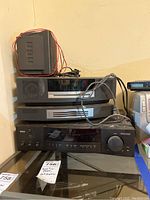 Stacked Bose CD player and RCA amplifier with wires on top, showing front panels.
