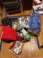 View of assorted memorabilia including bags, shirts, blankets, and coins on floor