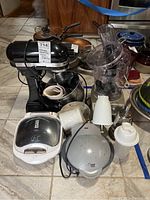 Full lot overview with KitchenAid mixer, blender with food processor attachment, Lean Mean Fat Grilling Machine, waffle maker, and other blender components.