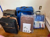 Photo of all three luggage items grouped on wooden floor next to wall.