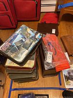 Stack of vintage firm leatherette portfolios and carrying totes showing varied colors and printed covers, including a M&Ms Mars Candy advertisement tote.