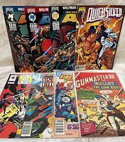 Front view of 9 assorted comic books arranged in 2 rows showing various titles and covers.