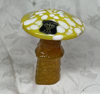 Front view showing the art glass mushroom with amber stem and yellow and white spotted cap, with Golden Crown E & R label on cap.