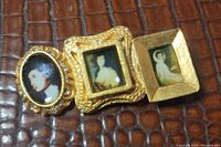 Front view of brooch showing three linked portrait frames