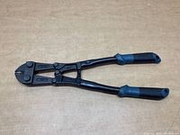 Full view of bolt cutters with blue and black rubber grip handles and black metal cutting head.