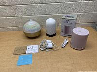 Full lot showing the three aroma diffusers, power cords, adapters, manuals, and diffuser box