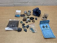 Photo showing entire assortment of rocks, minerals, polished stones, and jewelry components laid out on table.