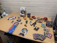 Full overview of assorted toys including Funko Pop, toy cars, Star Wars and Pokémon cards laid on table