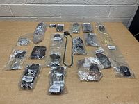 Overview of the entire lot showing many individually bagged jewelry items on a wooden table.