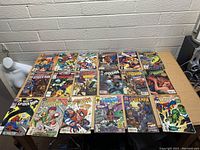 Photo of 20 Spider-Man comics displayed on a table in protective sleeves showing front covers and variety of title series.