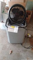 Black Honeywell fan sitting on top of white Hisense dehumidifier, showing general view of both appliances.